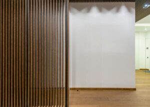Espace intérieur minimaliste avec panneaux de bois et décoration moderne, présentant des lignes épurées et un design contemporain.