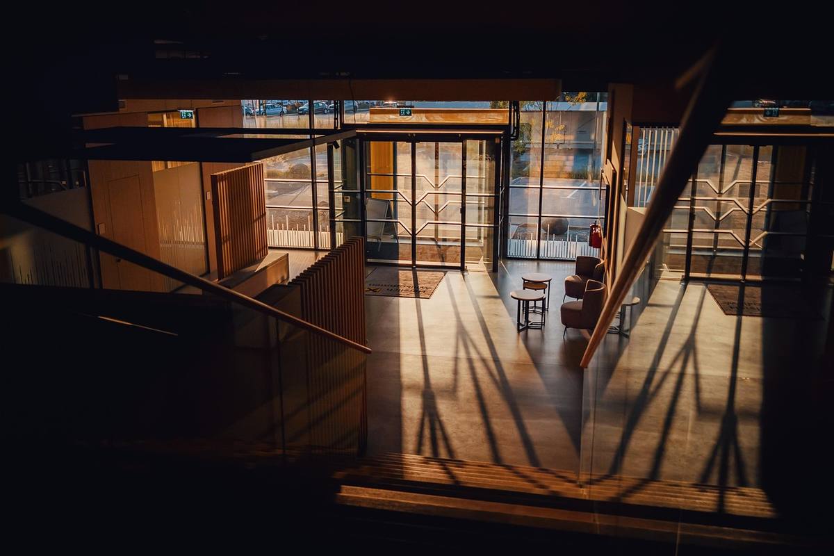 Vue d'une salle lumineuse avec escalier fenêtres et ombres projetées